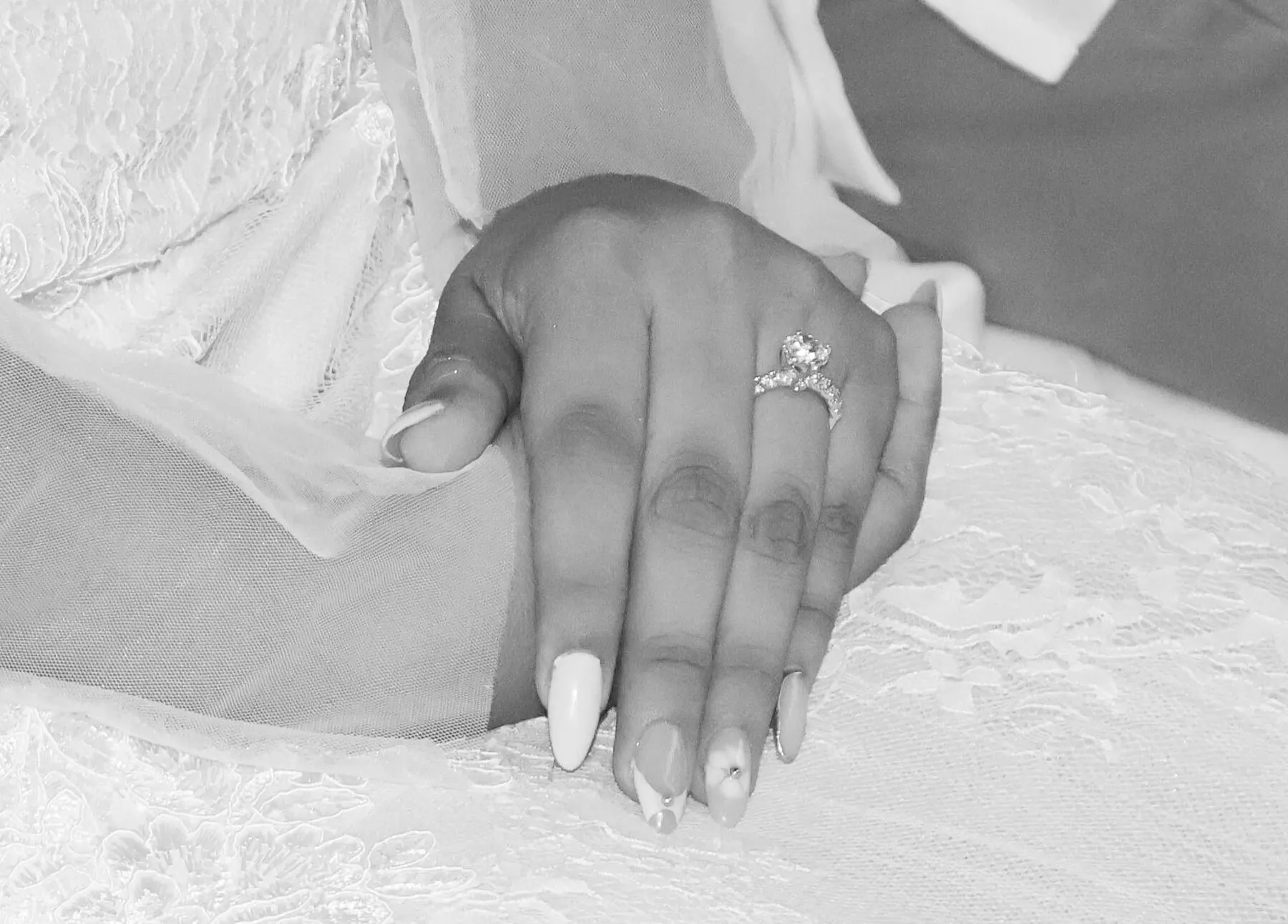 Manos con el anillo de compromiso, en blanco y negro