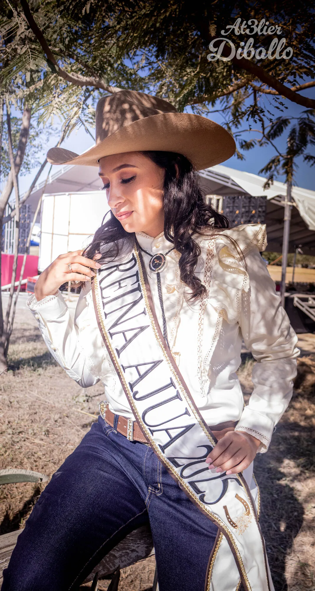 Reina charra con banda, sentada en una cerca